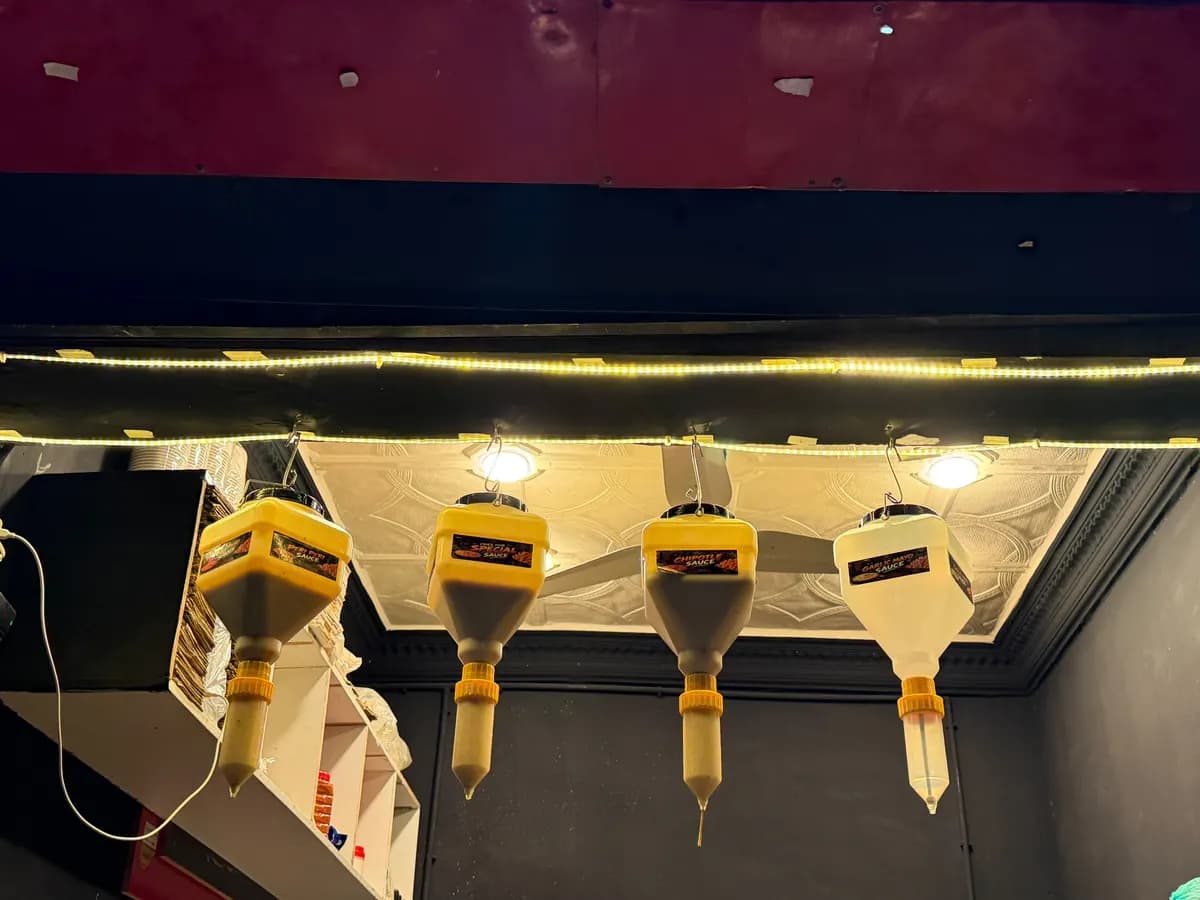 Four sauce dispensers hanging in the Fries Hub kitchen